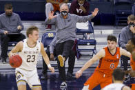 Virginia Tech coach Mike Young makes a kicking motion during the first half of the team's NCAA college basketball game against Notre Dame on Wednesday, Jan. 27, 2021, in South Bend, Ind. (AP Photo/Robert Franklin)