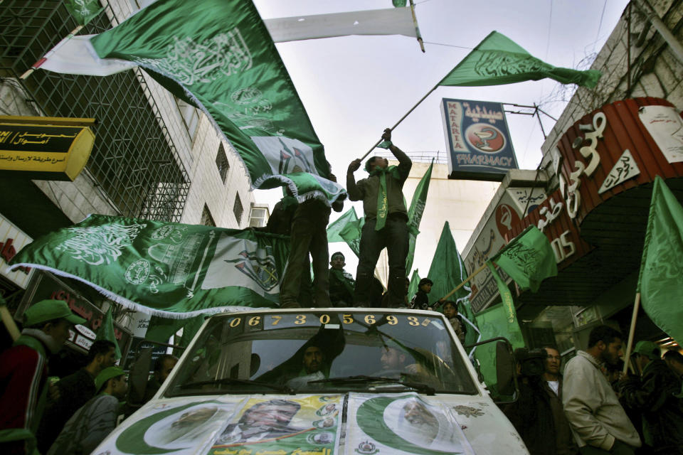 FILE - Palestinian supporters of the Islamic Hamas wave green Islamic flags during a pre-election rally in the West Bank town of Ramallah, Monday, Jan. 23, 2006. Palestinians plastered walls with posters, strung up banners and cruised the streets with loudspeakers Monday on the final day of campaigning before parliamentary elections. (AP Photo/Muhammed Muheisen, File)