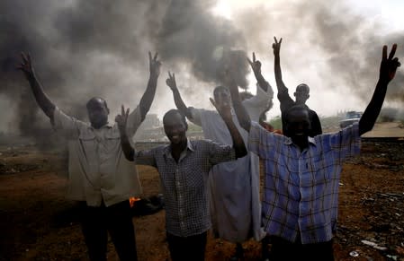Sudanese protesters gesture as they chant slogans along a street and demanding that the country's Transitional Military Council hand over power to civilians in Khartoum