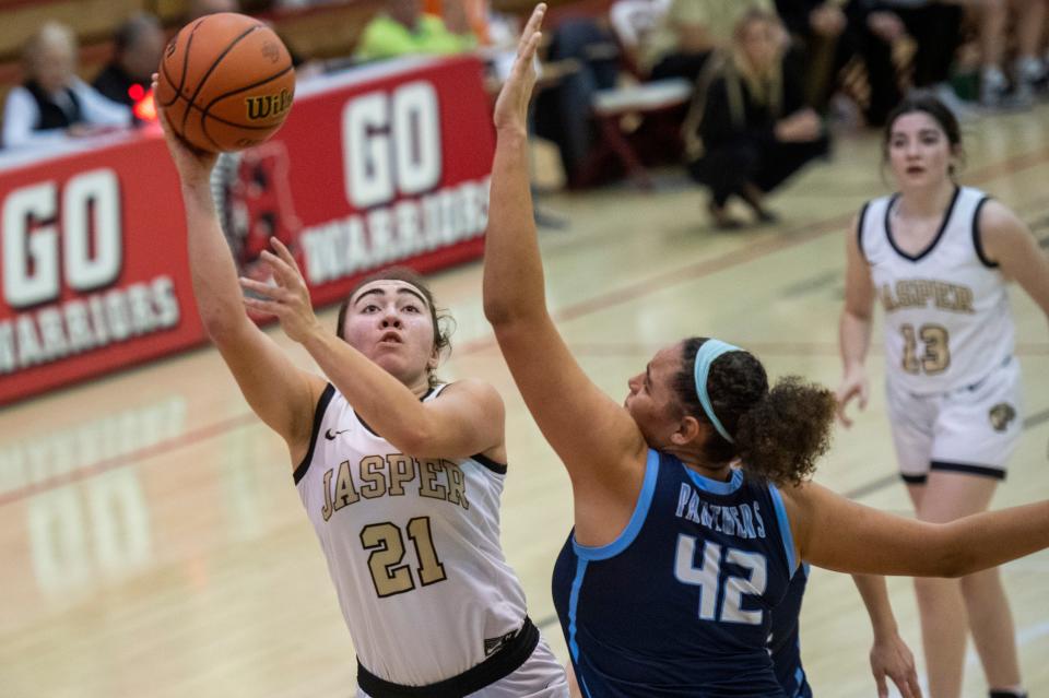 Jasper’s Emma Schipp (21) takes a shot around Reitz’s Kaelyse Mitchell (42) as the Reitz Panthers play the Jasper Wildcats during the semifinal round of the 2023 IHSAA Class 4A Girls Basketball Sectional at Harrison High School in Evansville, Ind., Friday, Feb. 3, 2023.