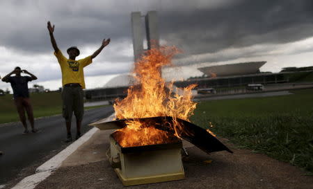 Demonstrators burn a coffin that represents Brazil's President Dilma Rousseff during a protest calling for the impeachment of Rousseff in front of the National Congress in Brasilia, Brazil, December 13, 2015. REUTERS/Ueslei Marcelino