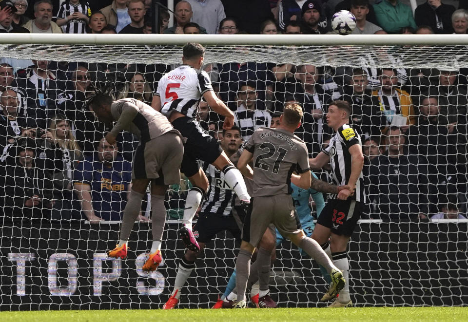 Newcastle United's Fabian Schar, centre top, scores their side's fourth goal during the English Premier League soccer match between Newcastle United and Tottenham Hotspur at St. James' Park in Newcastle, England, Saturday, April 13, 2024. (Owen Humphreys/PA via AP)