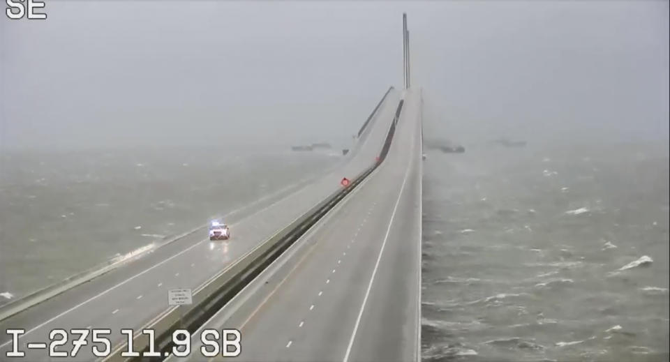 An emergency vehicle travels the Sunshine Skyway over Tampa Bay