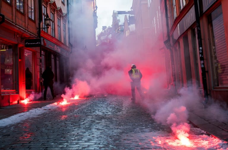 Counter-protesters throw flairs toward police officers as they demonstrate against the neo-nazi Nordic Resistance Movement rally, in central Stockholm on November 12, 2016