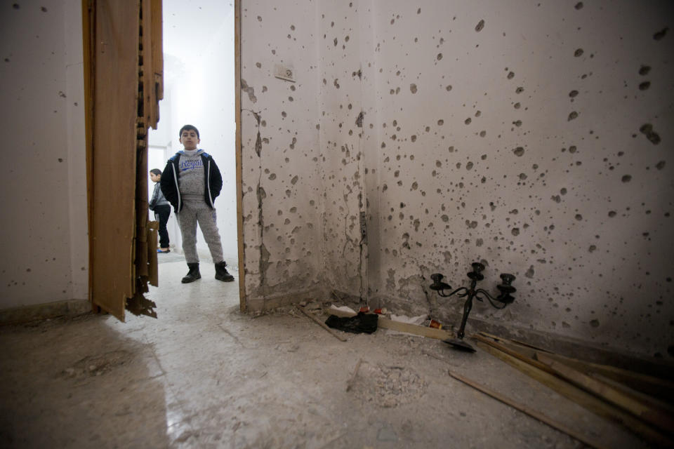 A Palestinian boy looks at a damage after an Israeli raid killed Ashraf Naalweh during an arrest raid in the Asker refugee camp near the West Bank city of Nablus, Thursday, Dec. 13, 2018. Israel accuses Naalweh of shooting to death two Israelis and wounding another at an attack on a West Bank industrial zone in October. He fled the scene and Israeli forces have been searching for him since. (AP Photo/Majdi Mohammed)