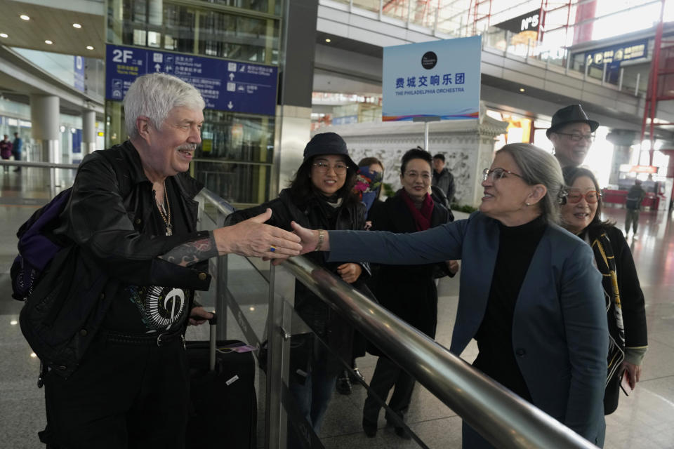 Philadelphia Orchestra's 73-year-old violinist Davyd Booth, left, is greeted by Shari Bistransky, Counselor for Public Affairs of the United States Embassy to China, at the Beijing Capital International Airport on Tuesday, Nov. 7, 2023. Musicians from the Philadelphia Orchestra arrived in Beijing on Tuesday, launching a tour commemorating its historic performance in China half a century ago in signs of improving bilateral ties ahead of a highly anticipated meeting between President Joe Biden and Xi Jinping. (AP Photo/Ng Han Guan)