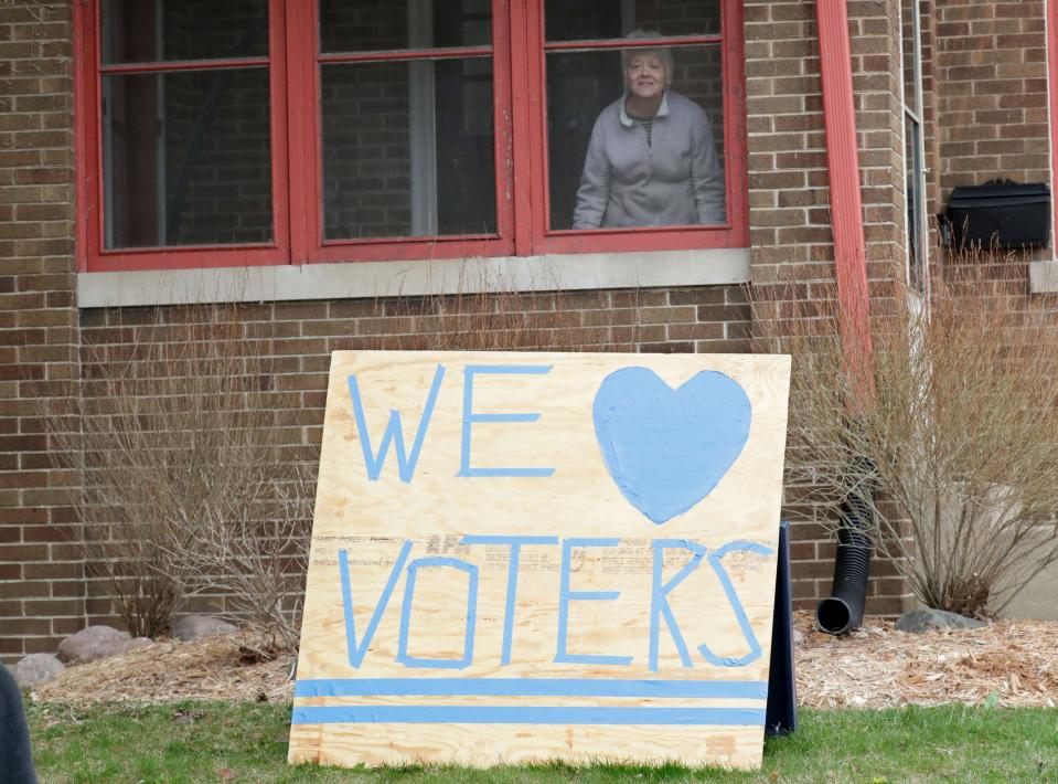 Susan Pitts posted a sign showing her support for voters voting at nearby Riverside High School, 1615 E. Locust St. in Milwaukee on Tuesday, April 7, 2020. The Wisconsin primary is moving forward despite the coronavirus epidemic after Gov. Tony Evers sought to shut down Tuesday's election in a historic move Monday that was swiftly rejected by the conservative majority of the Wisconsin Supreme Court.