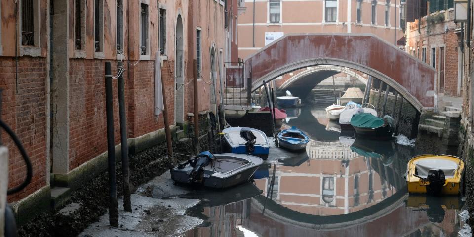 Boats are pictured in a canal during a severe low tide in the lagoon city of Venice on February 17 2023