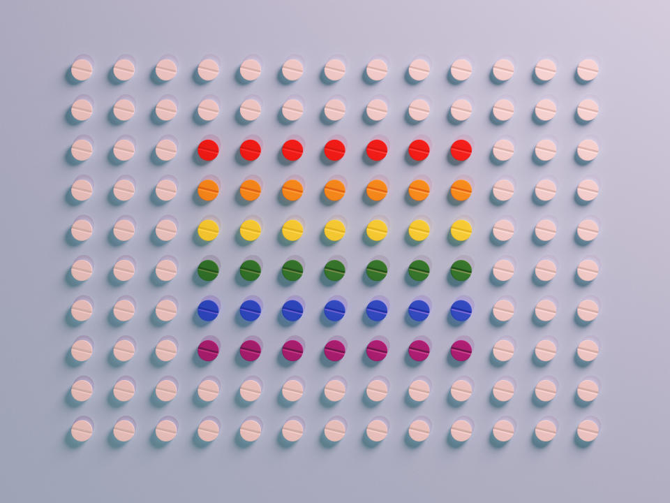 Conceptual of a grid pattern of pills with some colored in rainbow colors, could illustrate ideas around puberty blockers and transgender hormone therapy and other medication for the lgbtq community