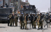 Police officers prepare to leave after conducting a crackdown against supporters of Tehreek-e-Labiak Pakistan, a banned Islamist party, protesting the arrest of their party leader, in Lahore, Pakistan, Sunday, April 18, 2021. A crackdown by security forces on protesting supporters of the banned party left several people dead and many others, including police officers, injured, a police spokesman said Sunday. (AP Photo/K.M. Chaudary)