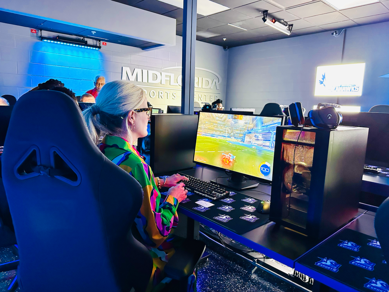 Commissioner Stephanie Madden tries playing Rocket League on one of 20 computer setups purchased for the city's new esports center using the $74,900 donated by MidFlorida Credit Union.