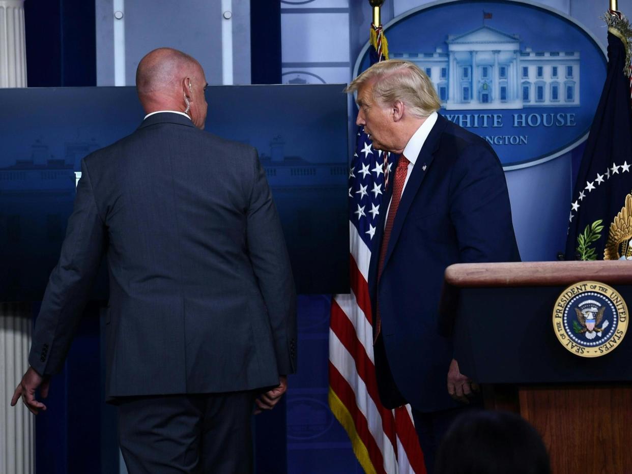 Donald Trump removed by member of the secret service from the Brady Briefing Room of the White House: AFP via Getty