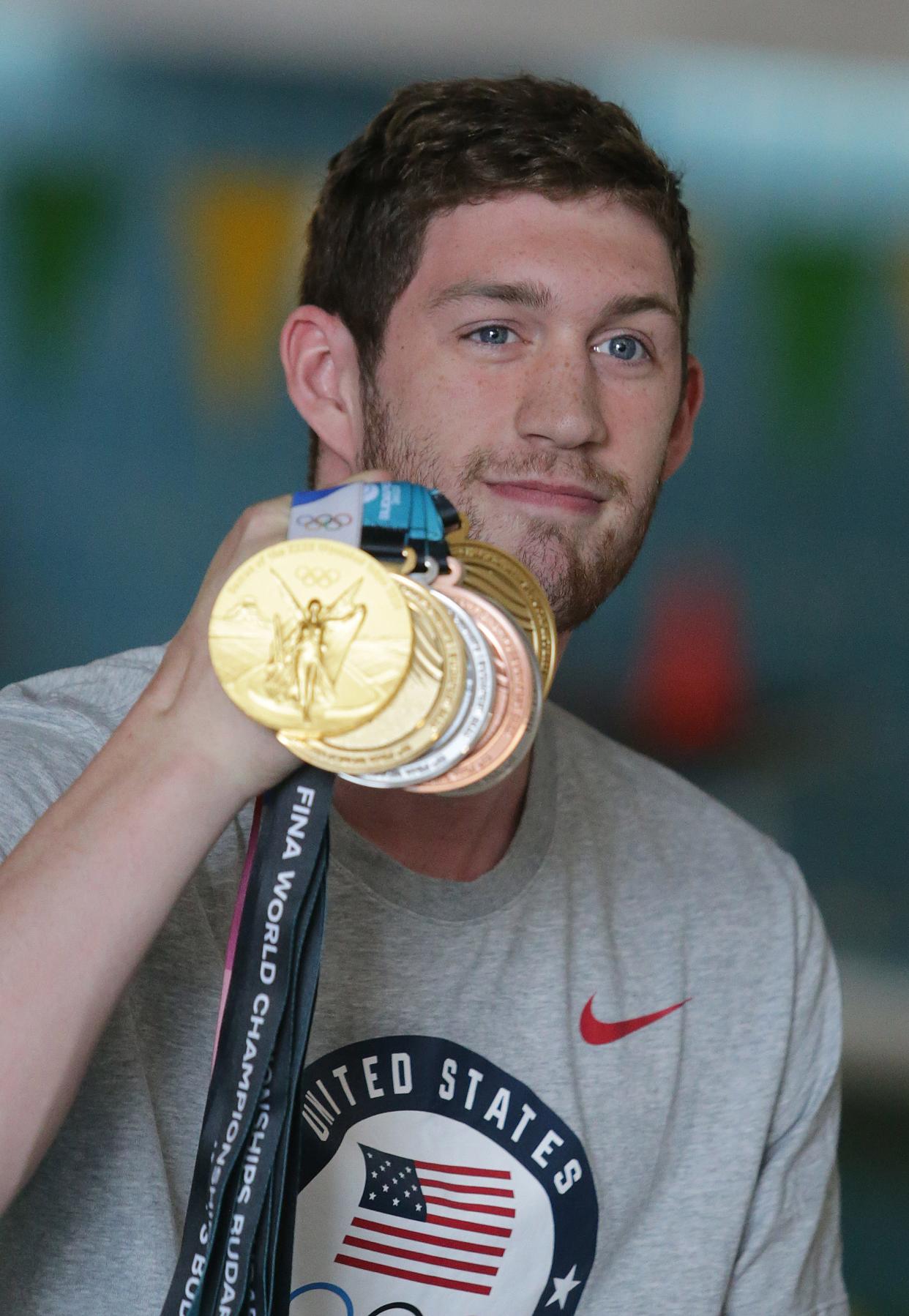 Olympic gold medalist Hunter Armstrong shows off his medals to young swimmers at the Massillon YMCA. Armstrong, a Dover native, struck gold at the Tokyo Olympics as a member of the 4x100 meter medley relay. He earned five other medals at last month's FINA Swim World Championships.