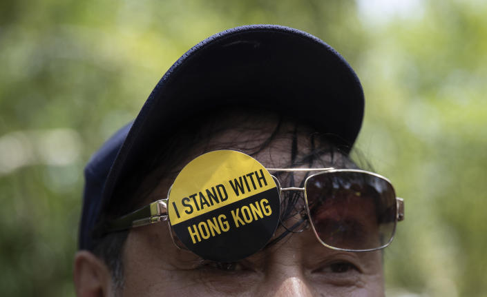 A man with a sticker that reads "I Stand With Hong Kong" on his glasses gathered with others in Lafayette Square in front of the White House in Washington, Sunday, Aug. 18, 2019, in solidarity with the "Stand With Hong Kong, Power to the People Rally" in Hong Kong. (AP Photo/Carolyn Kaster)
