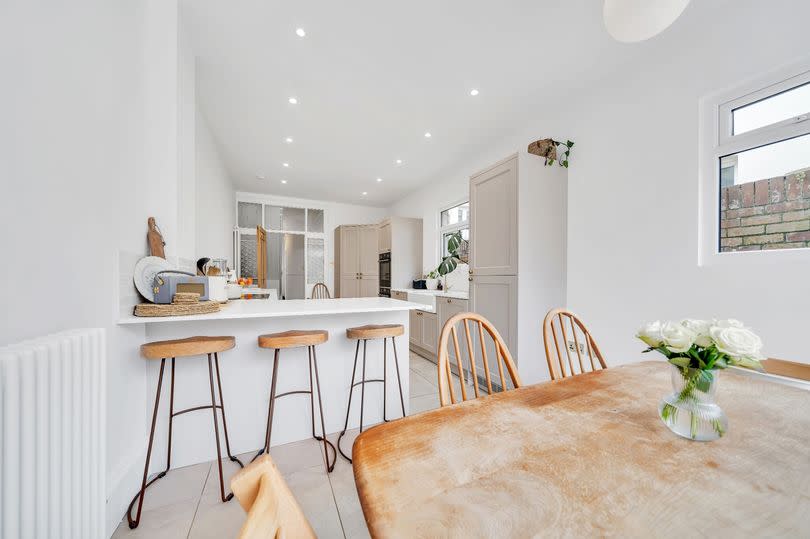 AFTER: A sociable space that continues the mix of white and neutral, natural materials with classic furniture design