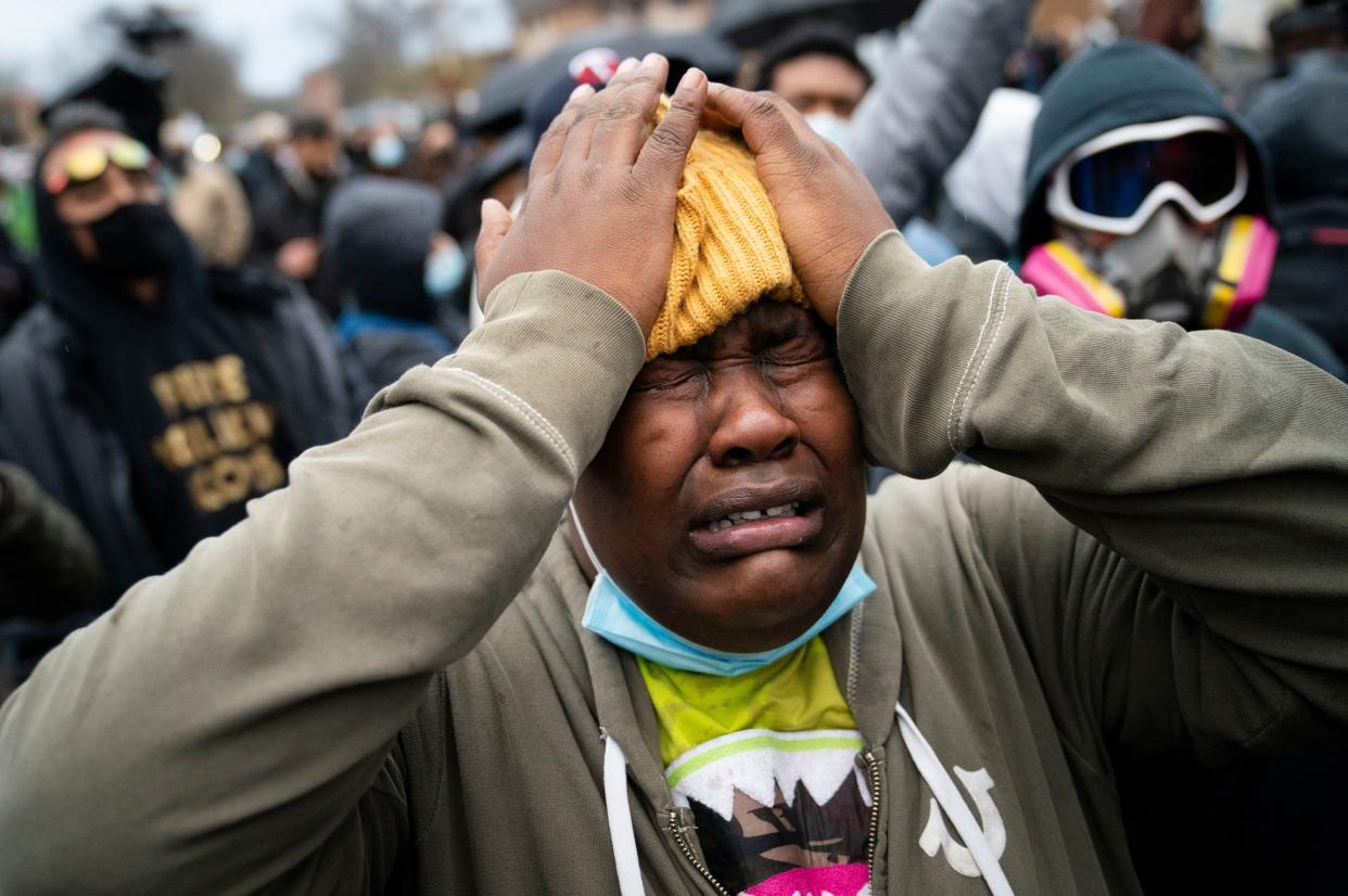 A demonstrator reacts during a standoff with police along a perimeter fence during a protest decrying the shooting death of Daunte Wright, outside the Brooklyn Center Police Department, Wednesday, April 14, 2021, in Brooklyn Center, Minn.