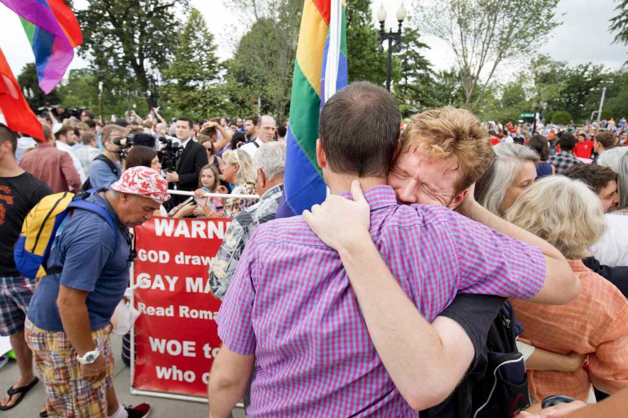 John Becker, right, hugs his friend and fellow LGBT advocate Paul Guequierre, outside the Supreme Court in Washington, Friday, June 26, 2015, after the court declared that same-sex couples have a right to marry anywhere in the US.
