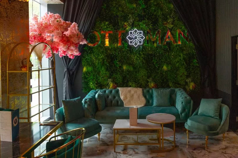 A botanical feature wall provides a place of solace near the restaurant's bar area