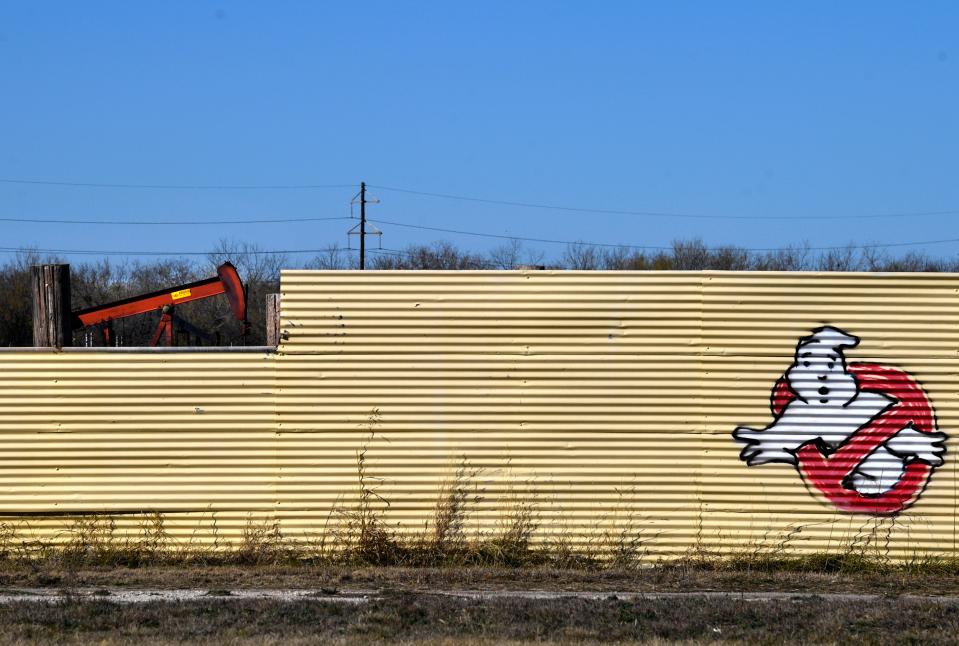 A Sojourner Oil pump jack can be seen through a break in the fence at Town & Country Drive-In Dec. 29. The closed drive-in is across the street from the Burger St. drilling site and next door to Ortiz Elementary School.