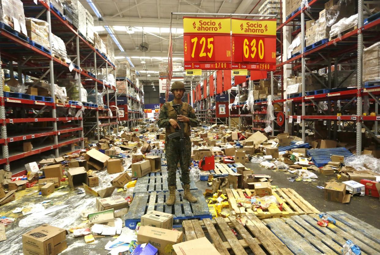 <span class="caption">A Chilean soldier stands guard at a ransacked supermarket in Santiago, October 2019.</span> <span class="attribution"><a class="link " href="https://www.gettyimages.com/detail/news-photo/chilean-soldier-stands-guard-at-a-supermarket-after-it-was-news-photo/1177544361?adppopup=true" rel="nofollow noopener" target="_blank" data-ylk="slk:Marcelo Hernandez/Getty Images;elm:context_link;itc:0;sec:content-canvas">Marcelo Hernandez/Getty Images</a></span>