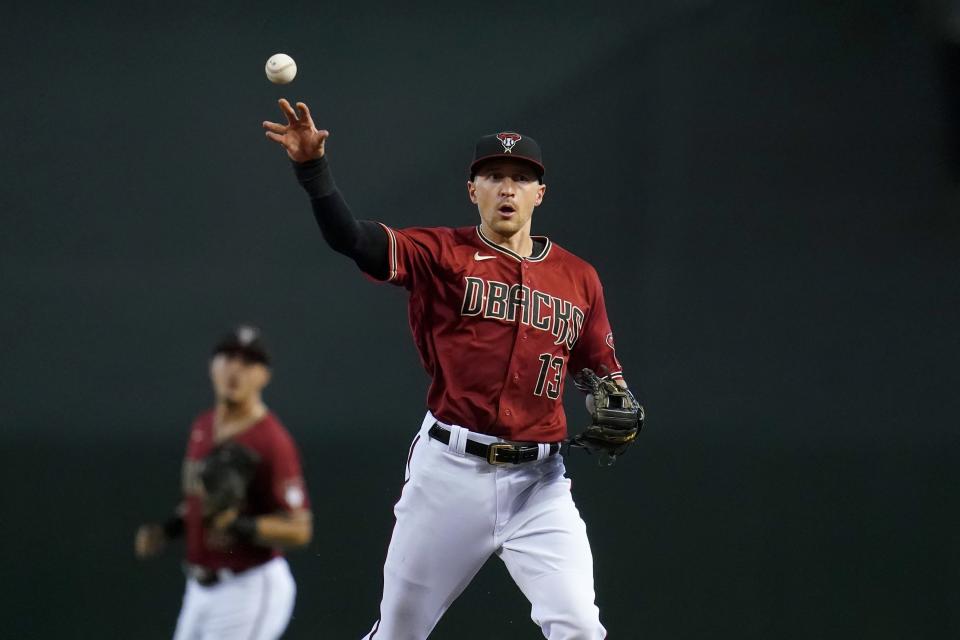 Arizona Diamondbacks shortstop Nick Ahmed (13) throws to first base to get out Chicago Cubs' Anthony Rizzo as Diamondbacks second baseman Josh Rojas looks on during the first inning of a baseball game, Sunday, July 18, 2021, in Phoenix. (AP Photo/Ross D. Franklin)