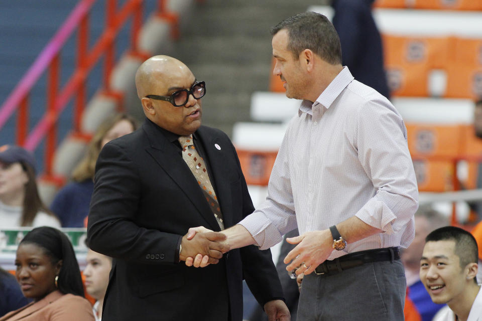 Syracuse head coach Quentin Hillsman, left, and Louisville head coach Jeff Walz, right, shake hands before an NCAA college basketball game in Syracuse, N.Y., Sunday, Feb. 9, 2020. (AP Photo/Nick Lisi)