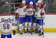 Montreal Canadiens defenseman David Savard, left, heads over to congratulate center Nick Suzuki, second from left, after his goal against the Colorado Avalanche during the first period of an NHL hockey game Tuesday, March 26, 2024, in Denver. Congratulating Suzuki are, from left, defenseman Arber Xhekaj, right wing Cole Caufield and left wing Juraj Slafkovsky. (AP Photo/David Zalubowski)