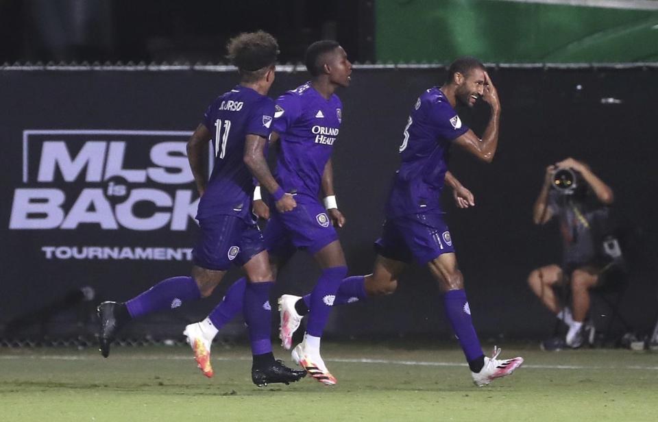 Tesho Akindele (derecha) festeja con otros jugadores de Orlando City tras anotar ante el New York City FC, el martes 14 de julio de 2020, en Kissimmee, Florida (Stephen M. Dowell/Orlando Sentinel via AP)