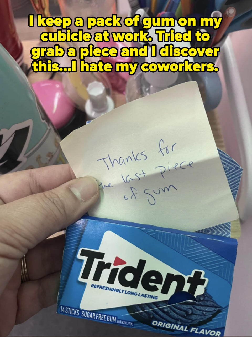 A note saying "Thanks for the last piece of gum" placed on a Trident gum pack, surrounded by office supplies