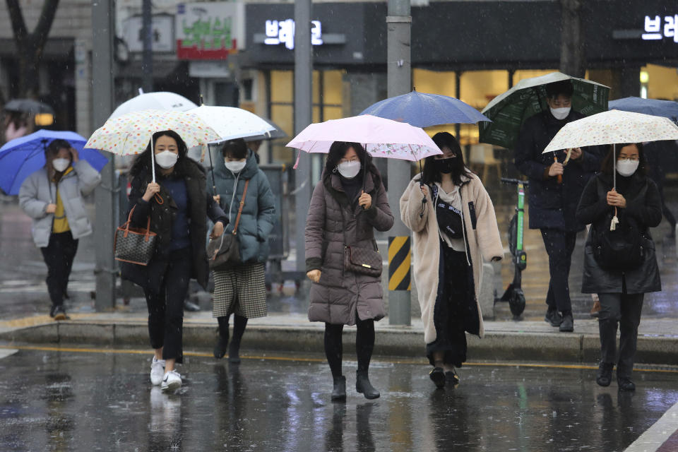 People wearing face masks walk on a street in Seoul, South Korea, Tuesday, Feb. 25, 2020. South Korea reported another large jump in new virus cases Monday a day after President Moon Jae-in called for "unprecedented, powerful" steps to combat the outbreak that is increasingly confounding attempts to stop the spread(AP Photo/Ahn Young-joon)