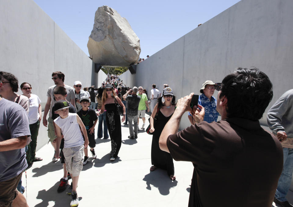 Visitors view Michael Heizer’s "Levitated Mass" at the Los Angeles County Museum of Art in Los Angeles, on Sunday June 24,2012. Thousands showed up as the gigantic work was unveiled on the museum’s rear lawn, where it is intended to remain forever. (AP Photo/Richard Vogel)