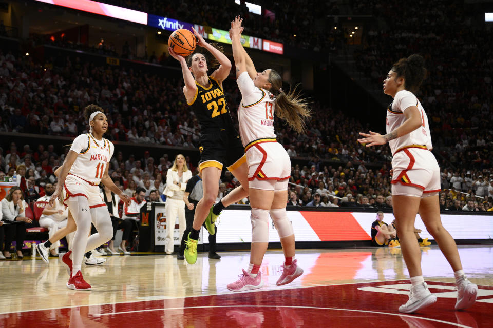 Iowa guard Caitlin Clark (22) goes to the basket against Maryland guards Jakia Brown-Turner (11), Faith Masonius (13) and Lavender Briggs (3) during the first half of an NCAA college basketball game, Saturday, Feb. 3, 2024, in College Park, Md. Masonius was charged with a foul on the play. (AP Photo/Nick Wass)