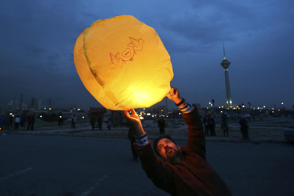 In this picture taken on Tuesday, March 18, 2014, an Iranian man releases a lit lantern during a celebration, known as “Chaharshanbe Souri,” or Wednesday Feast, marking the eve of the last Wednesday of the solar Persian year, in Pardisan park, Tehran, Iran. The festival has been frowned upon by hard-liners since the 1979 Islamic revolution because they consider it a symbol of Zoroastrianism, one of Iran’s ancient religions of Iranians. They say it goes against Islamic traditions. (AP Photo/Vahid Salemi)