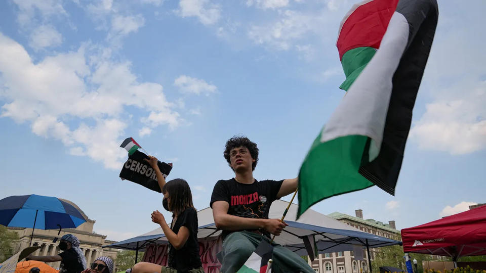 man waves Palestinian flag at Columbia University rally