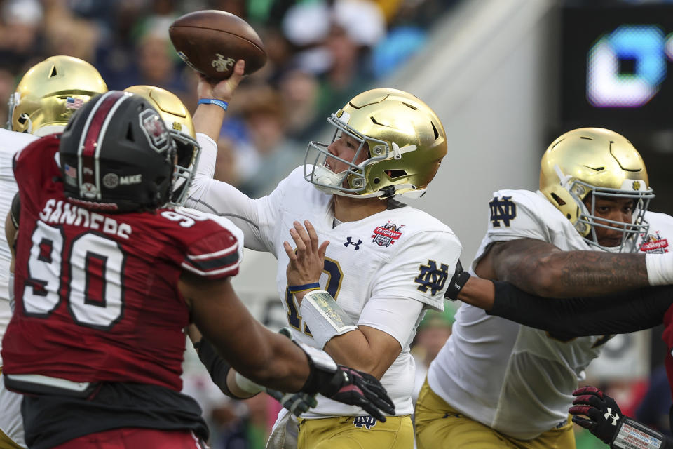 Notre Dame quarterback Tyler Buchner, center, looks to throw a pass during the first quarter of the Gator Bowl NCAA college football game against South Carolina on Friday, Dec. 30, 2022, in Jacksonville, Fla. (AP Photo/Gary McCullough)
