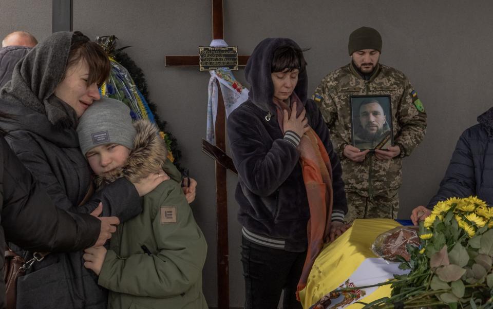 The wife and son (left) of Ukrainian serviceman killed near Avdiivka mourn next to his coffin
