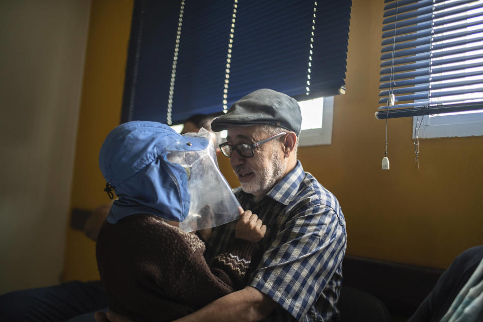 In this Wednesday, July 24, 2019 photo, Habib El Ghazaoui, a father who runs the Association for Solidarity with Children of the Moon, plays with 8 year-old Mustapha who is affected by a rare genetic disorder called xeroderma pigmentosum, or XP, inside a hospital in Casablanca, Morocco. (AP Photo/Mosa'ab Elshamy)