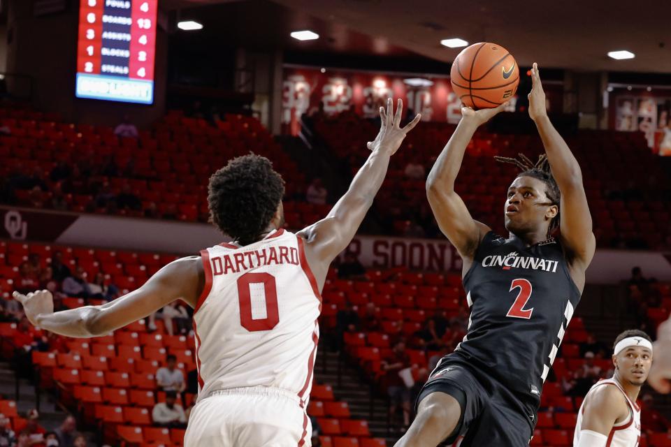 Bearcats guard Jizzle James  shoots over Oklahoma guard Le'Tre Darthard  Tuesday in Norman. James led the Bearcats with 16 points in their 74-71 overtime loss. Darthard led the Sooners with 18.