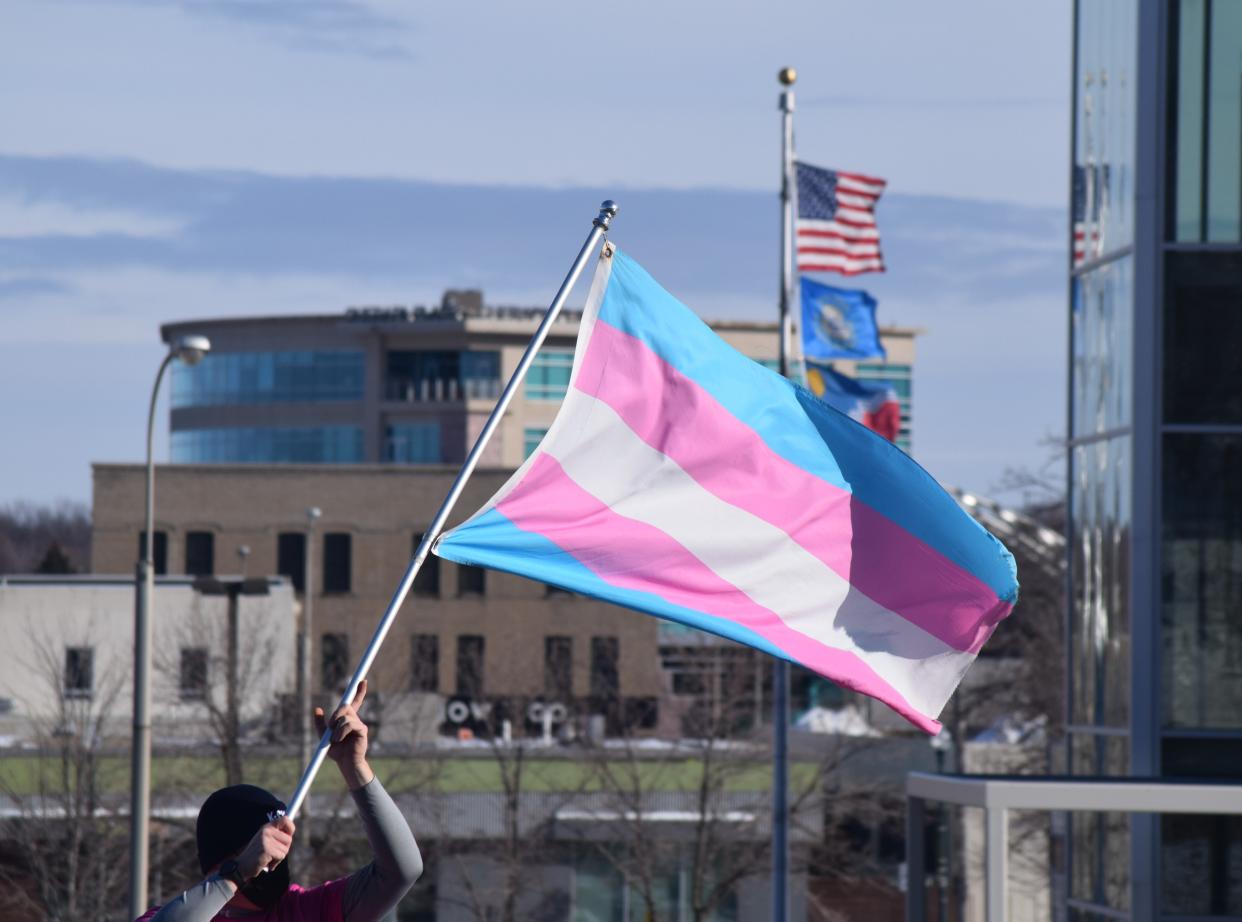 A protester holds a transgender pride flag as part of a "Protect Trans Kids rally" in Sioux Falls in 2022.