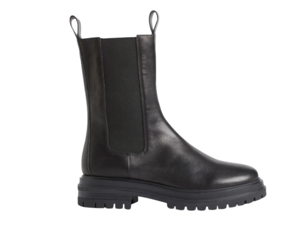 A side profile of high-top black leather Chelsea ankle boots against a white background.