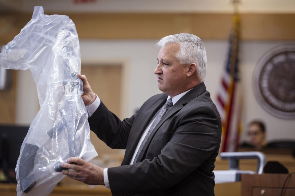 Prosecutor David Waymire shows the jury a AK-47 allegedly found in Muhammad Syed's possession, during opening statements in the trial of Syed at the Bernalillo County Courthouse in Downtown Albuquerque, N.M,, on Tuesday, March 12, 2024. Syed, an Afghan refugee, is accused in the slayings of three Muslim men in Albuquerque. (Chancey Bush/The Albuquerque Journal via AP, Pool)
