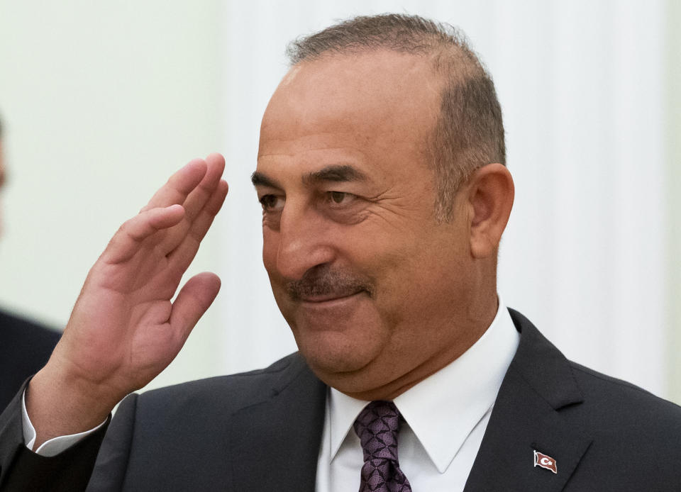 Turkish Foreign Minister Mevlut Cavusoglu salutes Russian President Vladimir Putin as he arrives to attend their talks in the Kremlin in Moscow, Russia, Friday, Aug. 24, 2018. Turkey's Foreign Minister on Friday warned against a possible Syrian government offensive on the last remaining stronghold of opposition against President Bashar Assad, while Russia indicated that it's losing its patience with the rebels. (AP Photo/Alexander Zemlianichenko, Pool)