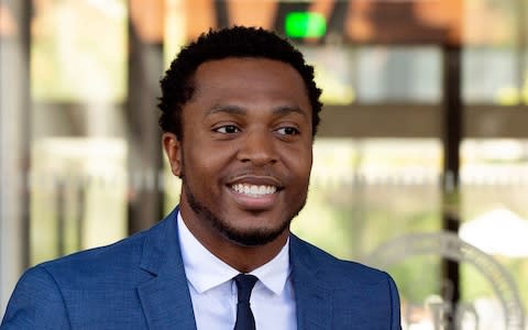 Rapper Marcus Gray smiles as he leaves the federal courthouse in Los Angeles  - Credit: AP