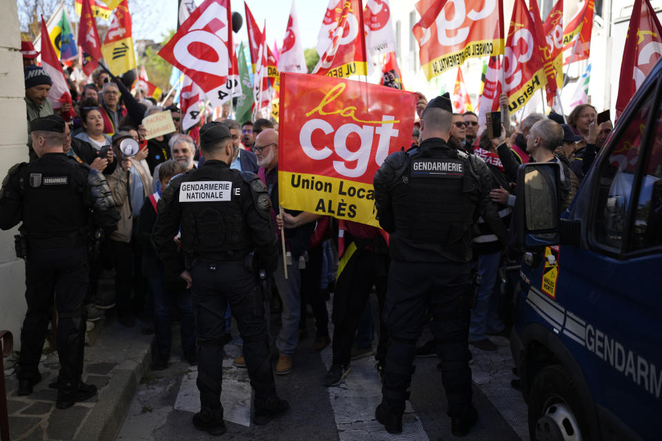 People demonstrate before French President Emmanuel Macron's visit, Thursday, April 20, 2023 in Ganges, southern France. The French leader tries to repair damage done to his presidency by forcing through unpopular pension reforms. Raising the retirement age from 62 to 64 has ignited a months-long firestorm of protest in France. (AP Photo/Daniel Cole)