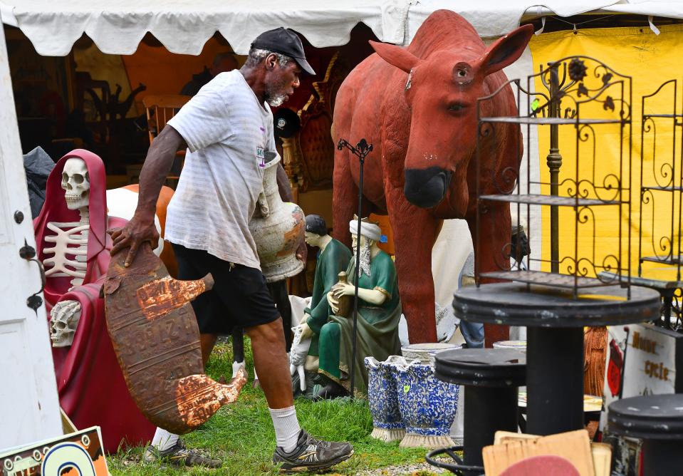 Leroy Diggs of Bridgerton, N.J., a former professional boxer and bodyguard, uses his strength to help set up Repo Depot's tent during setup day at the Brimfield Flea Market Monday.