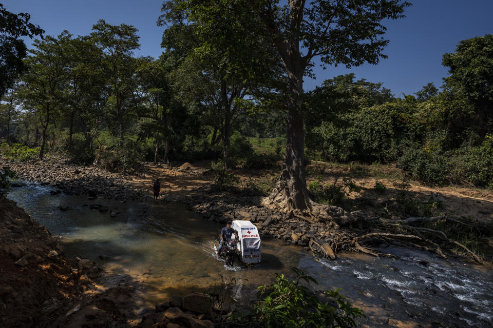 Sukhram Vadde, 24, drives a motorbike ambulance, a two-wheeler with a sidecar consisting of a hospital bed on wheels, across a stream through Abhujmarh, or "the unknown hills," to reach a pregnant woman in Kodoli, a remote village near Orchha in central India's Chhattisgarh state, Nov. 15, 2022. These ambulances, first deployed in 2014, reach inaccessible villages to bring pregnant women to an early referral center, a building close to the hospital where expectant mothers can stay under observation, routinely visit doctors if needed until they give birth. Since then the number of babies born in hospitals has doubled to a yearly average of about 162 births each year, from just 76 in 2014. The state has one of the highest rates of pregnancy-related deaths for mothers in India, about 1.5 times the national average, with 137 pregnancy related deaths for mothers per 100,000 births. (AP Photo/Altaf Qadri)