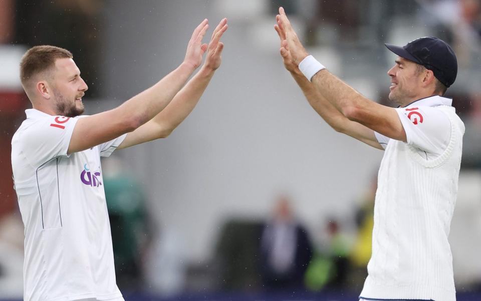 Gus Atkinson of England celebrates taking the wicket of Kirk McKenzie of West Indies with James Anderson during Day One of the 1st Rothesay Test Match between England and West Indies at Lord's Cricket Ground on July 10, 2024 in London, England