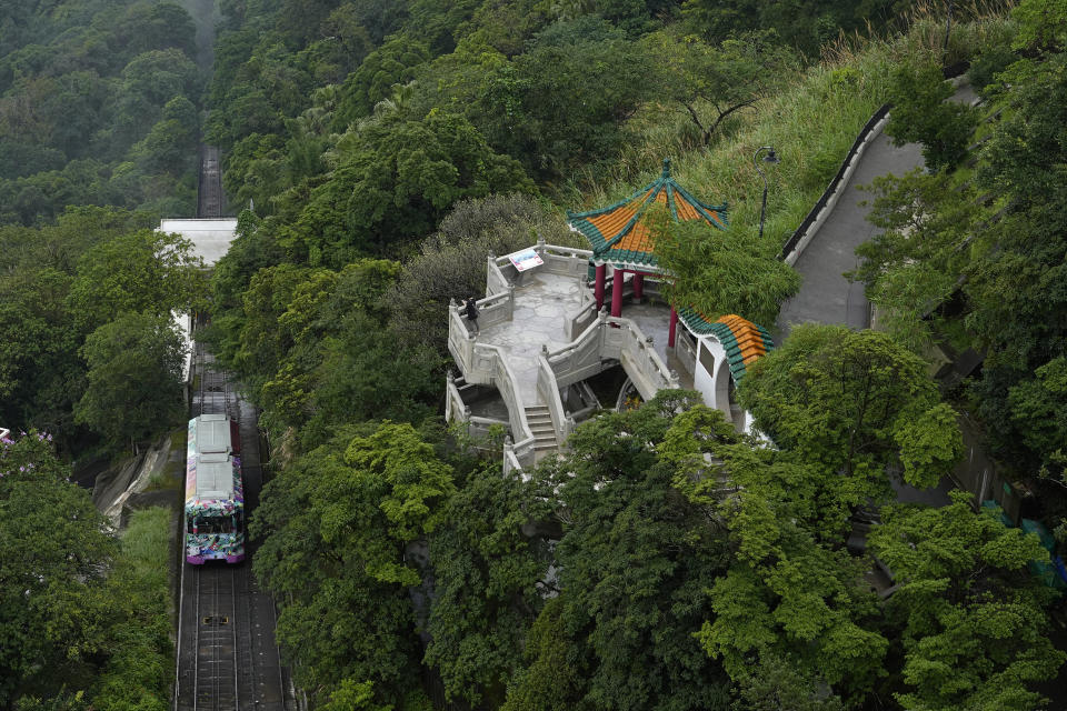 A Peak Tram passes uphill of the Victoria Peak in Hong Kong on June 17, 2021. Hong Kong’s Peak Tram is a fixture in the memories of many residents and tourists, ferrying passengers up Victoria Peak for a bird’s eye view of the city’s many skyscrapers. (AP Photo/Vincent Yu)