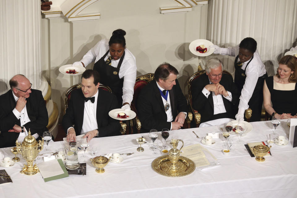 Guests including the Lord Mayor of the City of London, Roger Gifford (C), Chancellor of the Exchequer, George Osborne (2nd L), and Governor of the Bank of England, Mervyn King (3rd R), are served food at  the 'Lord Mayor's Dinner to the Bankers and Merchants of the City of London' at the Mansion House in London June 19, 2013. Britain is ready to start selling its shares in Lloyds Banking Group and will examine whether to break up Royal Bank of Scotland (RBS) , Finance Minister George Osborne said on Wednesday. REUTERS/Oli Scarff/POOL  (BRITAIN  - Tags: BUSINESS FOOD)  