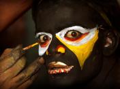 In this Monday, July 25, 2011 photograph, an Indian artist gets make up before a performance during a procession of "Bonalu" festival in Hyderabad, India. Bonalu is a Hindu folk festival of the Telangana region in the Indian state of Andhra Pradesh. (AP Photo/Mahesh Kumar A)